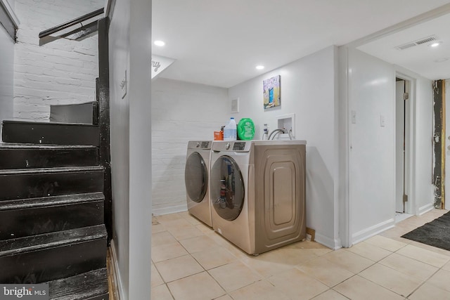 laundry area featuring washer and dryer and light tile patterned flooring