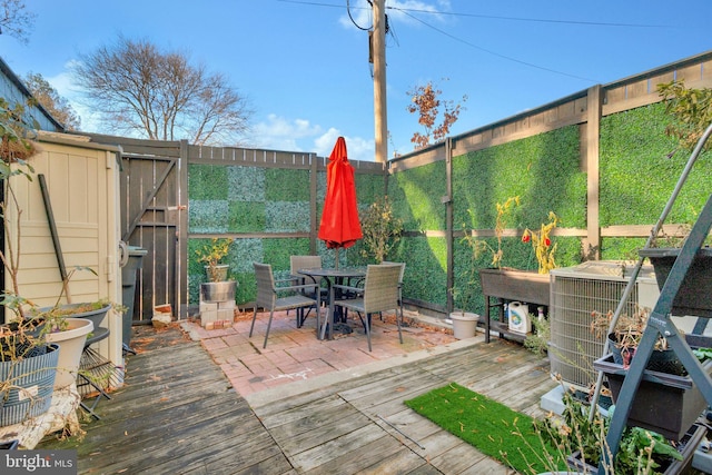 wooden deck featuring central AC and a storage unit