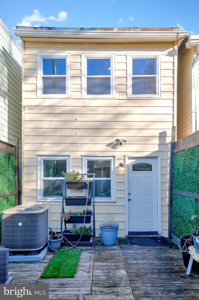 rear view of house with central air condition unit and a deck