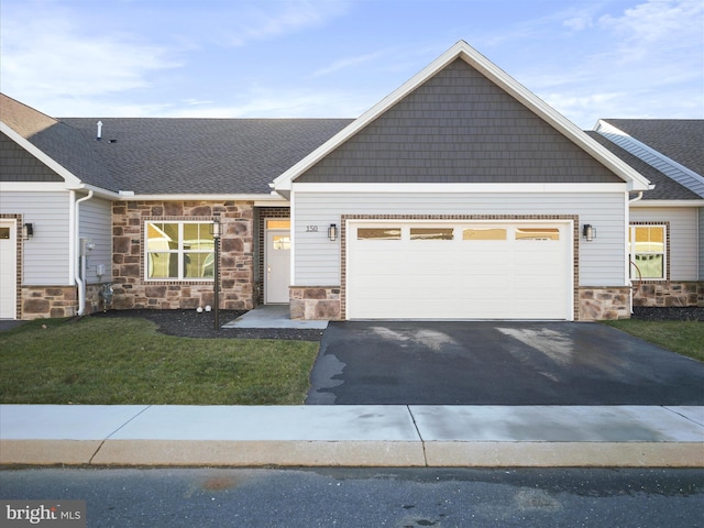 craftsman house with a garage and a front lawn