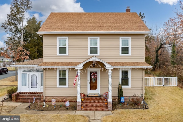 colonial-style house featuring a front yard