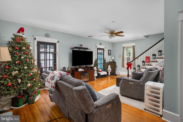 living room featuring a wealth of natural light, light hardwood / wood-style flooring, and ceiling fan