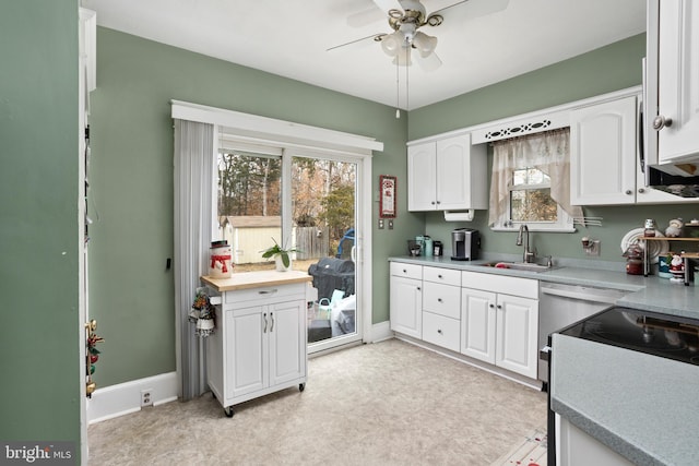 kitchen with white cabinets, ceiling fan, and sink