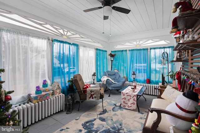 sunroom featuring radiator, ceiling fan, and a healthy amount of sunlight