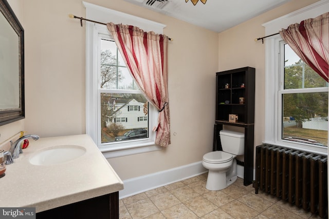 bathroom with tile patterned flooring, vanity, toilet, and radiator