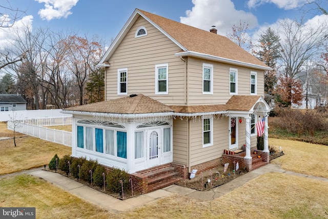 back of house featuring a yard and a sunroom