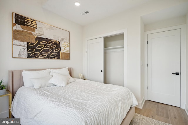 bedroom with light wood-type flooring and a closet