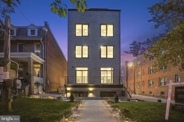 view of front of house featuring a yard and a balcony