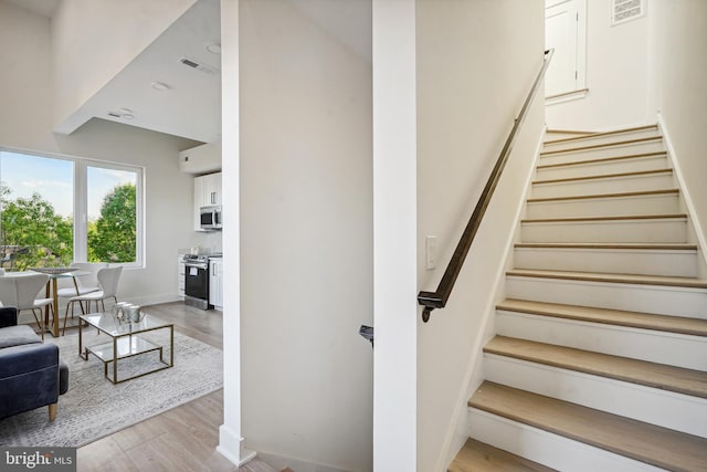 stairs featuring hardwood / wood-style floors