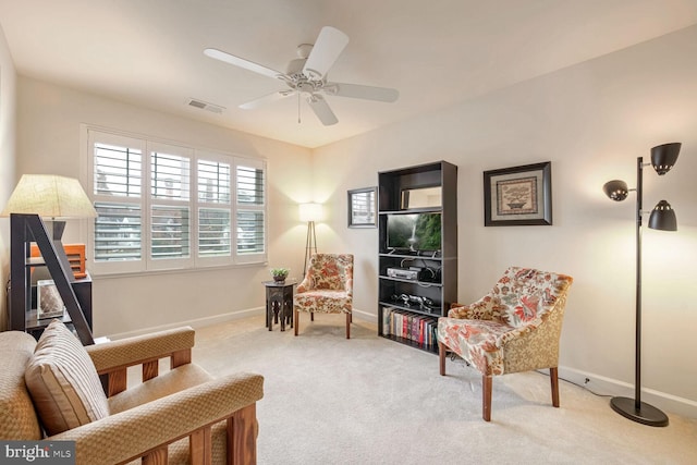 living area with ceiling fan and carpet