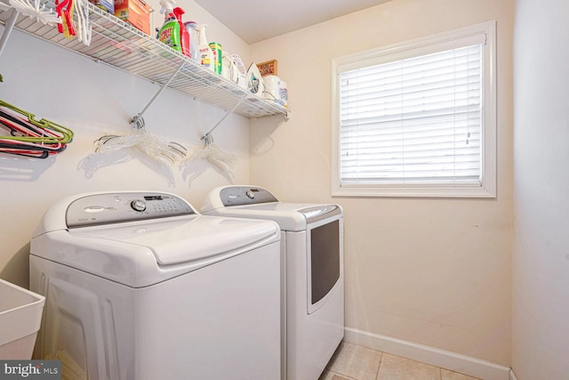 laundry room featuring light tile patterned floors, washing machine and dryer, and sink