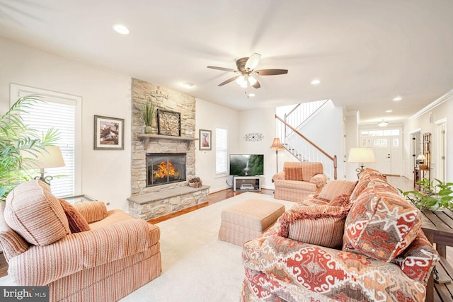 living room with hardwood / wood-style flooring, ceiling fan, a fireplace, and crown molding