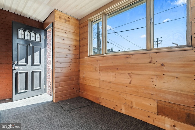 foyer with wooden ceiling and wood walls