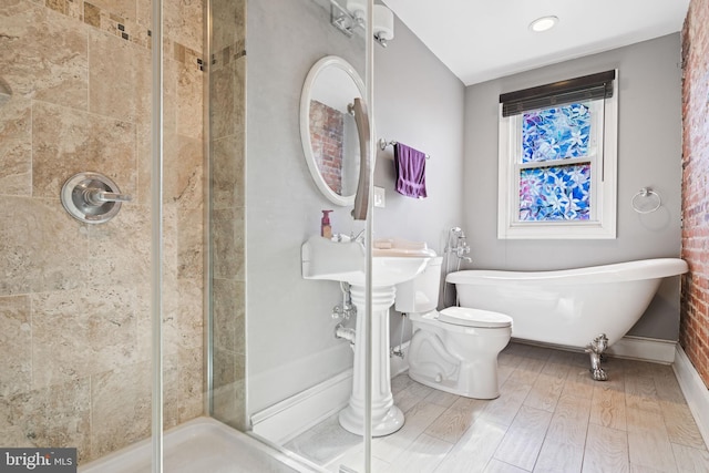 bathroom featuring tiled shower, hardwood / wood-style flooring, and toilet