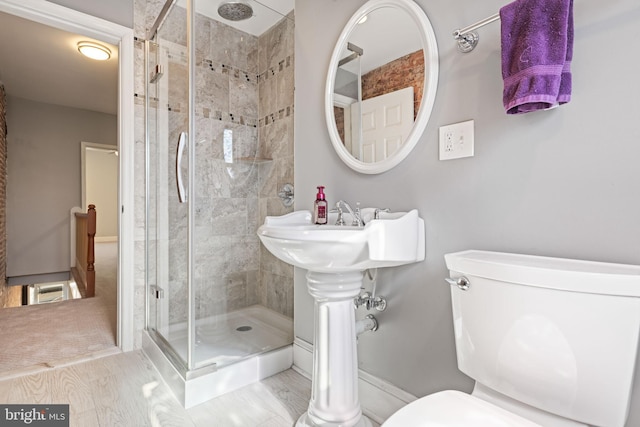 bathroom featuring a shower with door, wood-type flooring, and toilet