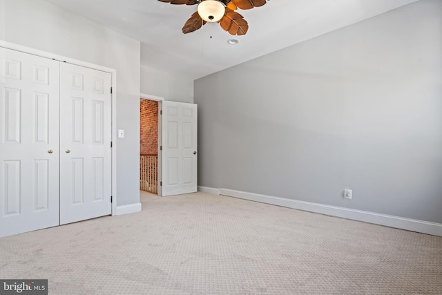 unfurnished bedroom featuring light carpet, a closet, and ceiling fan