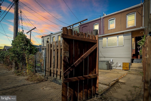 back house at dusk featuring central AC unit