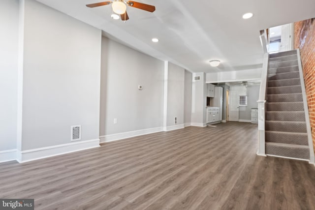 unfurnished living room featuring ceiling fan and dark hardwood / wood-style flooring