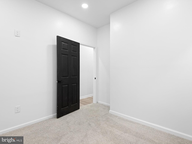 unfurnished room featuring light colored carpet