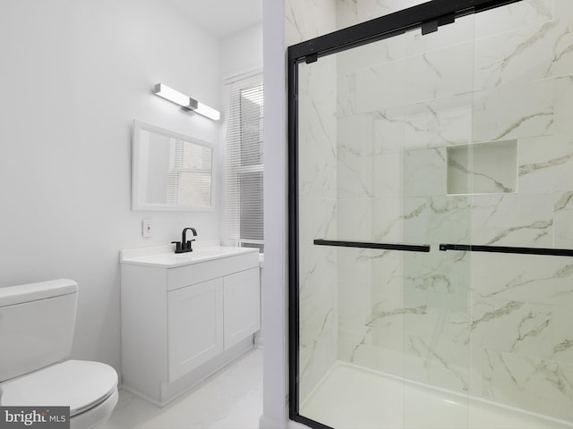 bathroom with vanity, toilet, and a shower with shower door