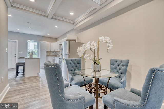 dining area with beam ceiling, crown molding, and light hardwood / wood-style floors