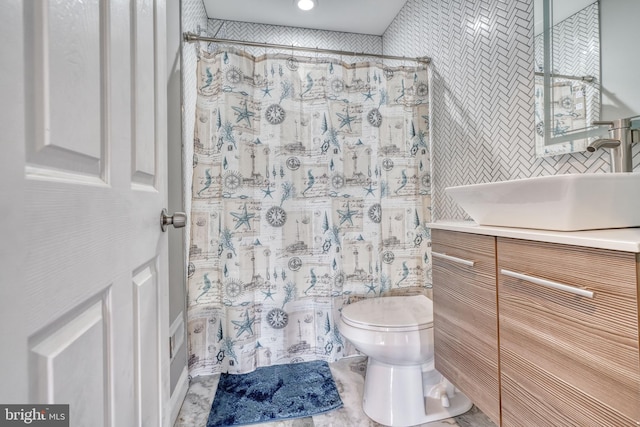 bathroom featuring walk in shower, vanity, and toilet