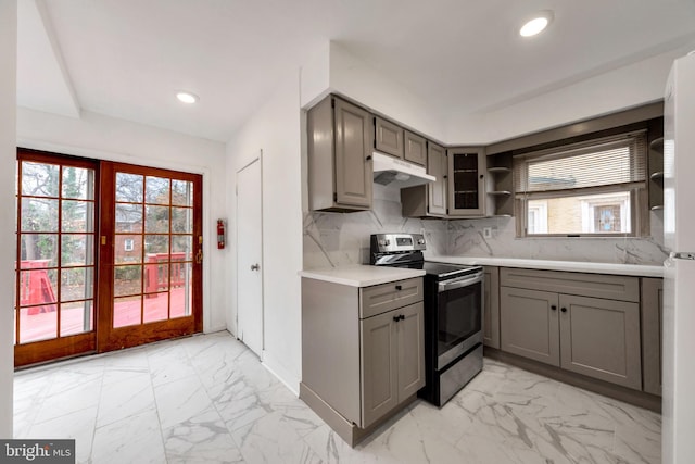 kitchen with stainless steel range with electric stovetop, plenty of natural light, gray cabinets, and decorative backsplash