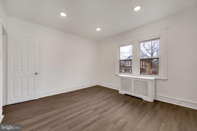 unfurnished room featuring dark wood-type flooring and radiator