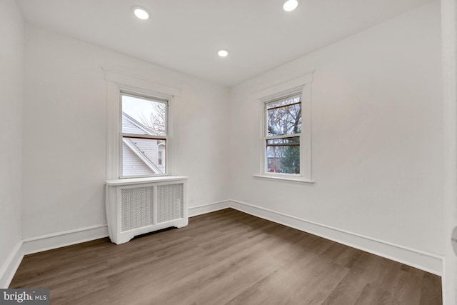 spare room with radiator heating unit and hardwood / wood-style floors