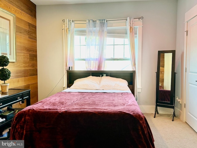 bedroom with carpet flooring and wooden walls