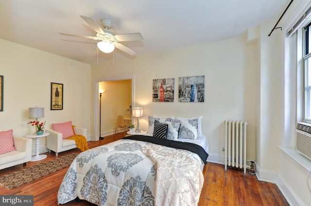 bedroom with dark hardwood / wood-style floors, ceiling fan, and radiator