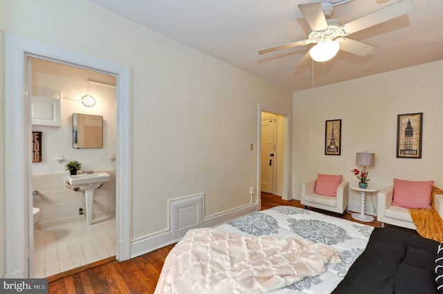 bedroom with ensuite bathroom, dark hardwood / wood-style floors, sink, and ceiling fan