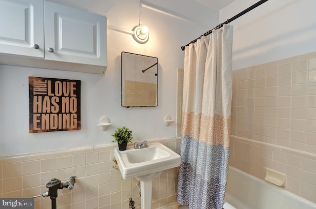 bathroom featuring shower / tub combo with curtain and tile walls