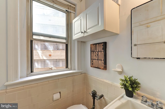 bathroom with tile walls and sink