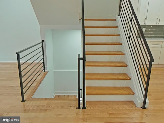 stairs featuring hardwood / wood-style flooring