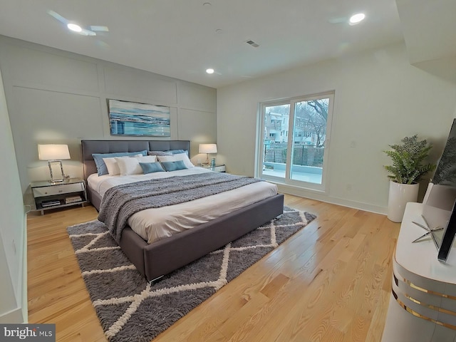 bedroom featuring access to exterior and light wood-type flooring