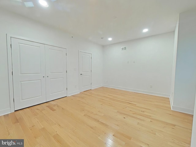 unfurnished bedroom featuring light hardwood / wood-style floors and a closet