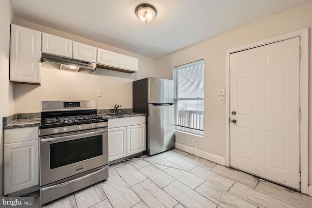 kitchen featuring dark stone countertops, white cabinetry, sink, and appliances with stainless steel finishes