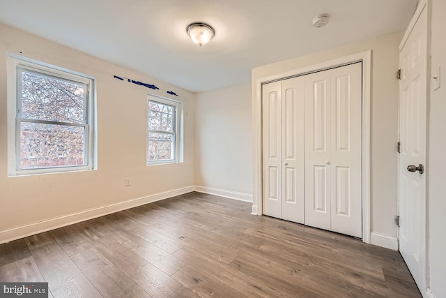 unfurnished bedroom featuring hardwood / wood-style floors and a closet