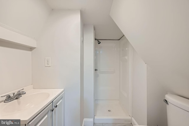 bathroom with toilet, vanity, and walk in shower