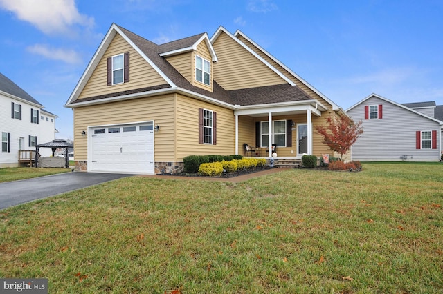 view of front of home featuring a front yard, a porch, and a garage