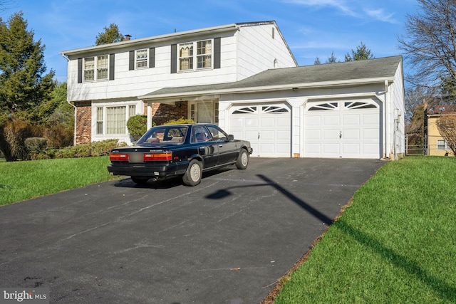 view of property featuring a front yard and a garage