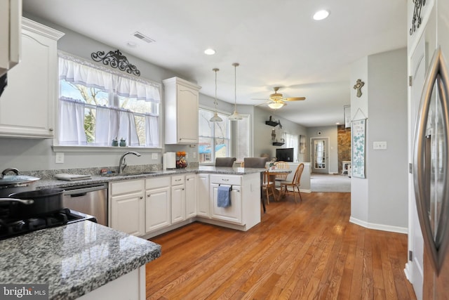 kitchen featuring white cabinets, kitchen peninsula, ceiling fan, and sink