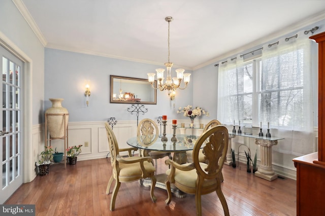 dining room with crown molding, dark hardwood / wood-style floors, and an inviting chandelier