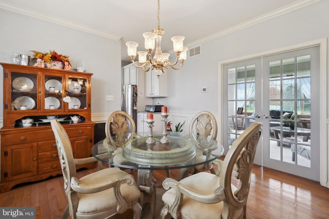 dining area featuring light hardwood / wood-style flooring, french doors, and ornamental molding