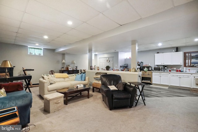 carpeted living room featuring a paneled ceiling