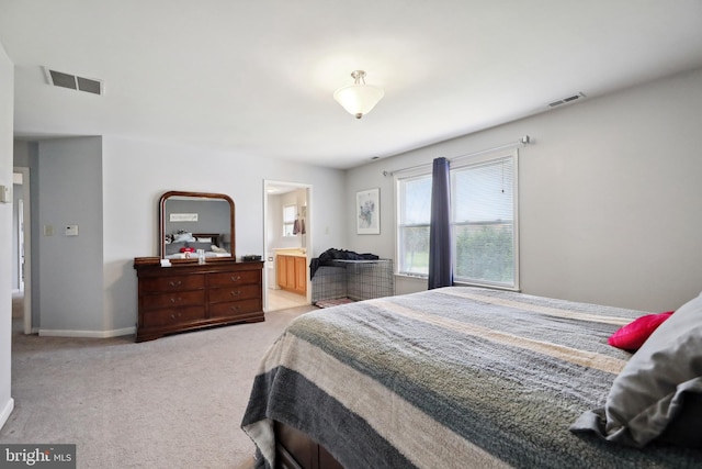 bedroom with connected bathroom and light colored carpet