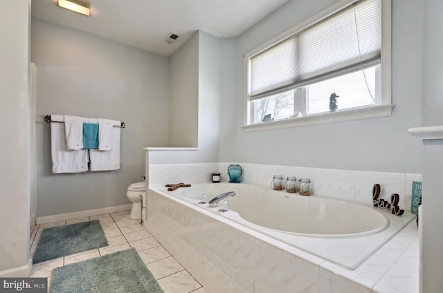 bathroom with tile patterned floors, toilet, and tiled tub