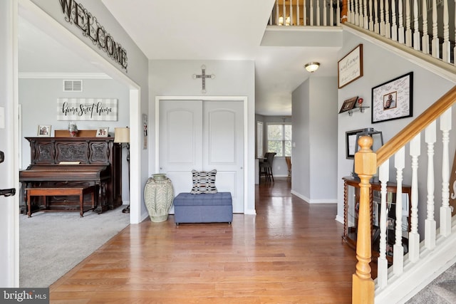 entryway with wood-type flooring and ornamental molding