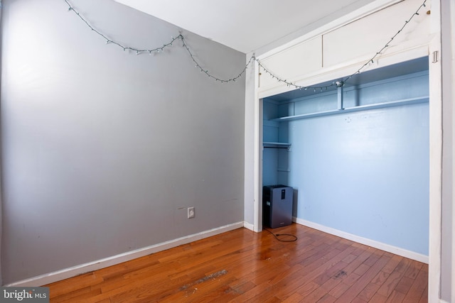 unfurnished bedroom featuring wood-type flooring and a closet